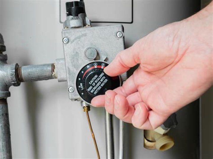 How do you adjust the temperature on a hot water cylinder?