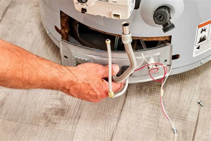 How do you manually light a Whirlpool water heater?