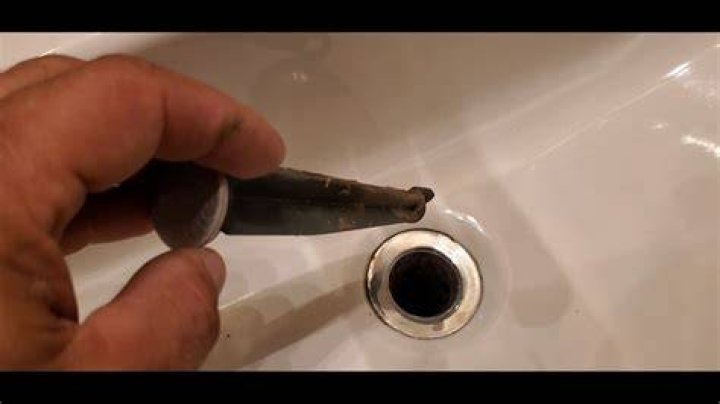 How do you reattach a bathroom sink stopper?