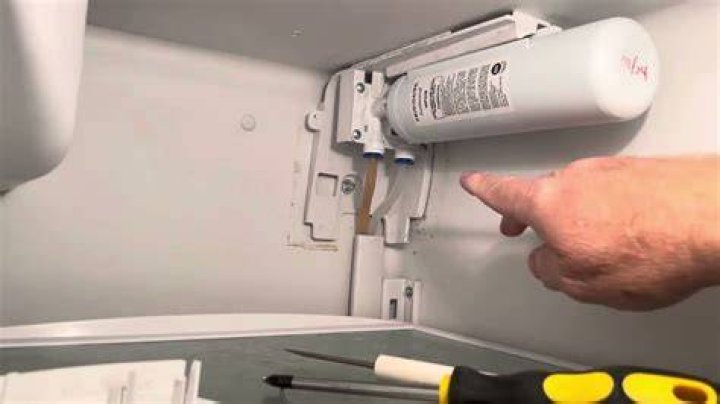 How do you remove a stuck refrigerator water filter?