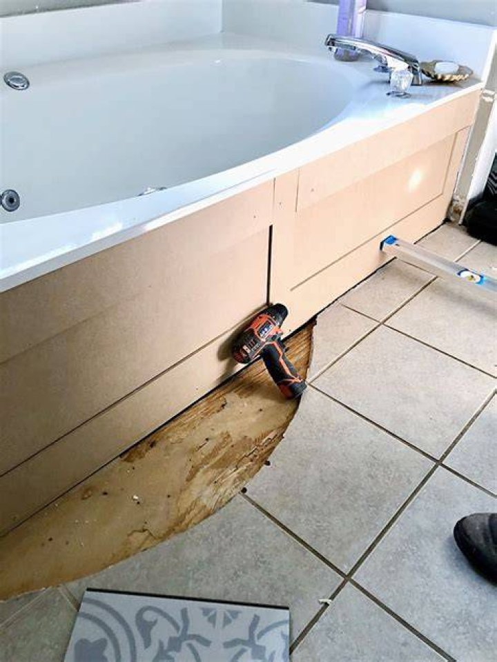 How do you remove the side panel on a Jacuzzi tub?